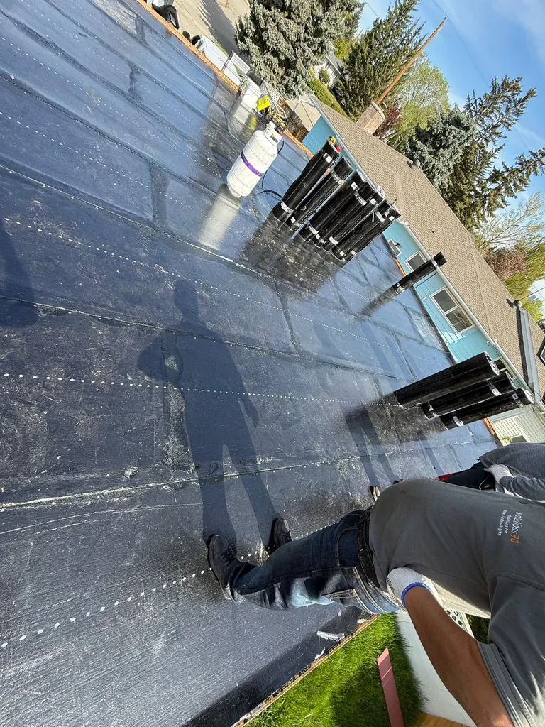 SBS torch-down membrane base sheet being installed with propane on a Calgary flat roof